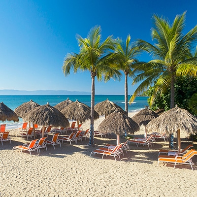 Sandy beach with lounge chairs and shade at Grand Matlali Hills Resort & Spa
