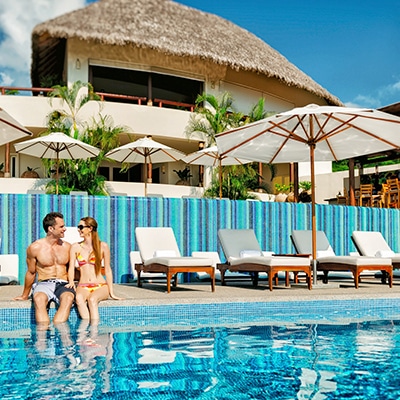 Young couple sitting at the pool at Grand Matlali Hills Resort & Spa